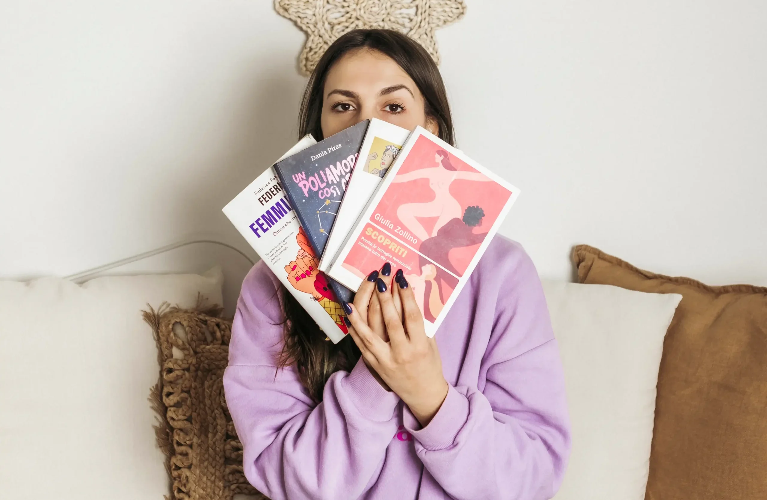 Immagine di Lucia con i libri che sono per lei rappresentativi del suo progetto unpopular